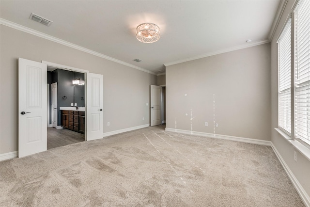 unfurnished bedroom with light colored carpet, ornamental molding, and ensuite bathroom