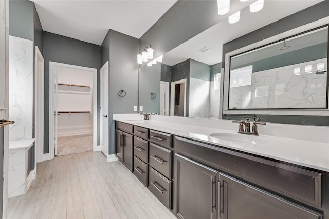 bathroom featuring hardwood / wood-style flooring, vanity, and a shower