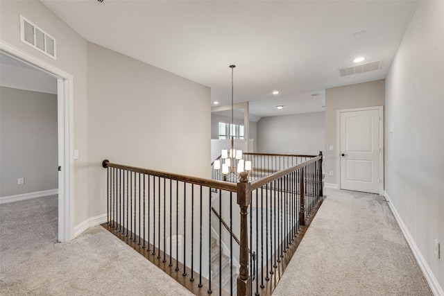 hall with carpet flooring and a notable chandelier