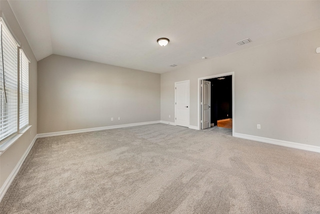 empty room featuring lofted ceiling and carpet