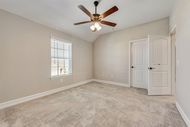 carpeted empty room with ceiling fan and vaulted ceiling