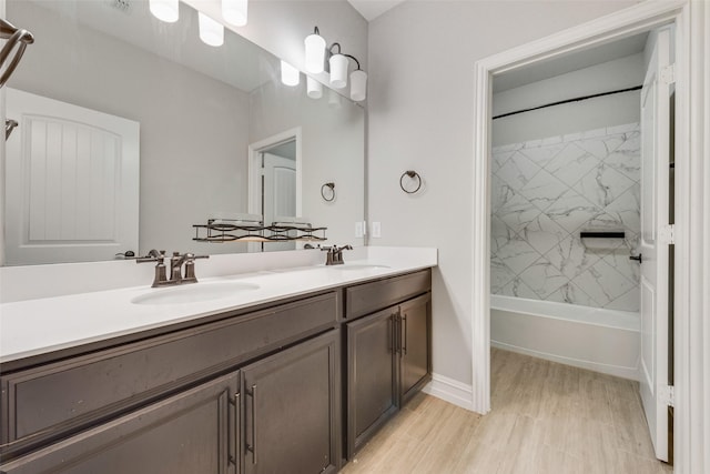 bathroom with tiled shower / bath combo, vanity, and hardwood / wood-style flooring