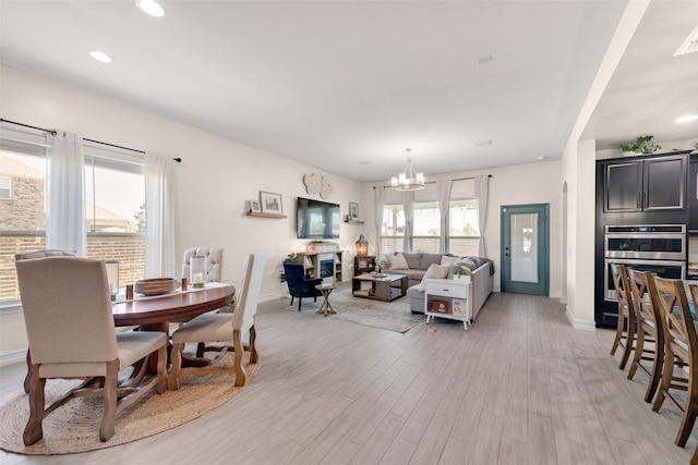 dining area with a notable chandelier and light hardwood / wood-style floors