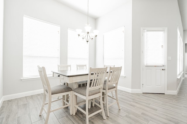 dining space featuring an inviting chandelier and light hardwood / wood-style flooring