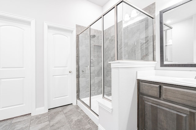 bathroom featuring a shower with door and vanity