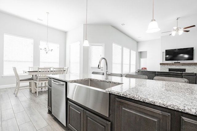 kitchen featuring ceiling fan with notable chandelier, sink, hanging light fixtures, stainless steel dishwasher, and dark brown cabinets