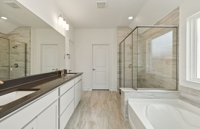 bathroom featuring separate shower and tub and vanity