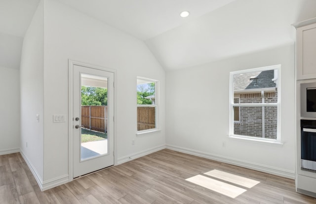 interior space with light hardwood / wood-style floors and vaulted ceiling