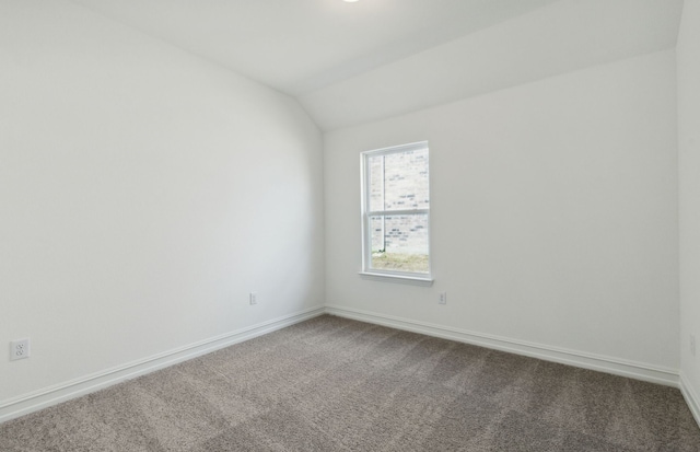 empty room with carpet and vaulted ceiling