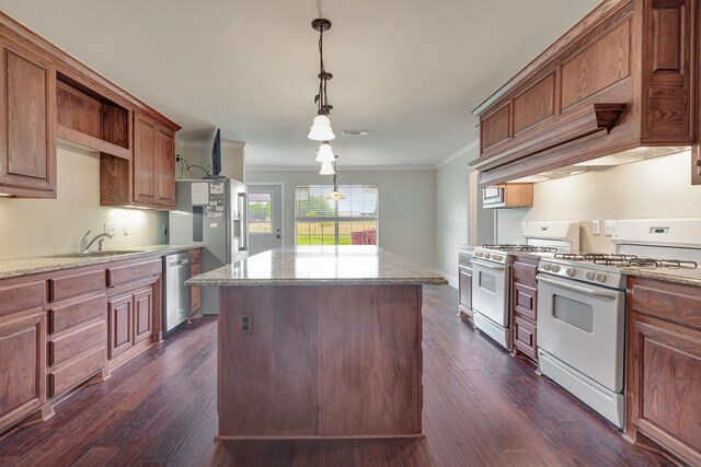 kitchen with appliances with stainless steel finishes, a kitchen island, ornamental molding, pendant lighting, and sink