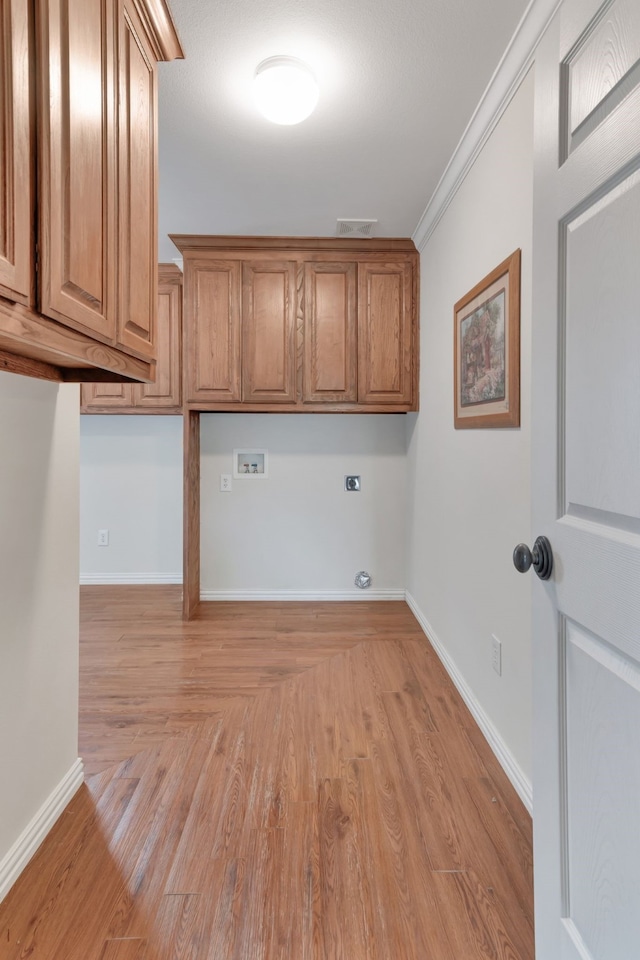 laundry room with light hardwood / wood-style floors, hookup for an electric dryer, hookup for a washing machine, cabinets, and crown molding