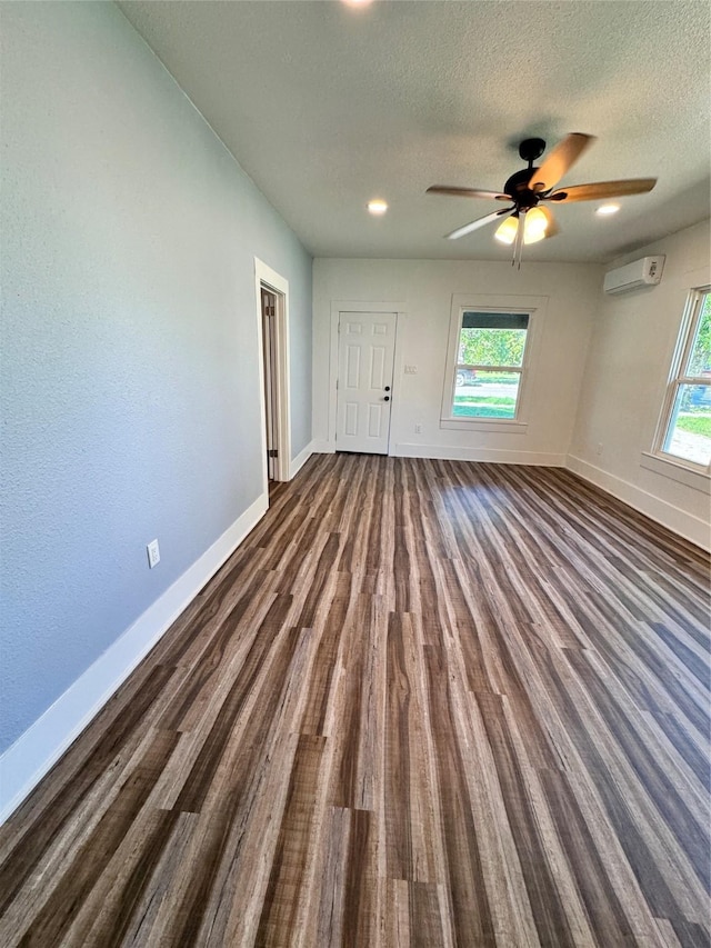 unfurnished bedroom with dark wood finished floors, a textured ceiling, and baseboards