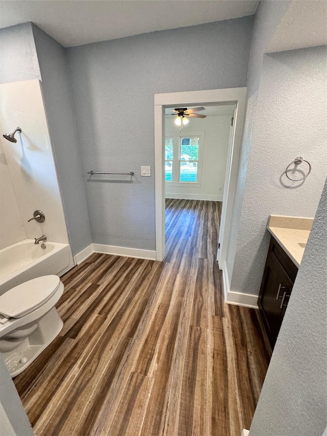 bathroom with baseboards, vanity, toilet, and wood finished floors