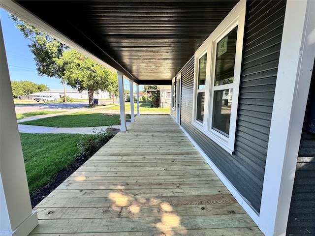 wooden terrace featuring a yard and a porch