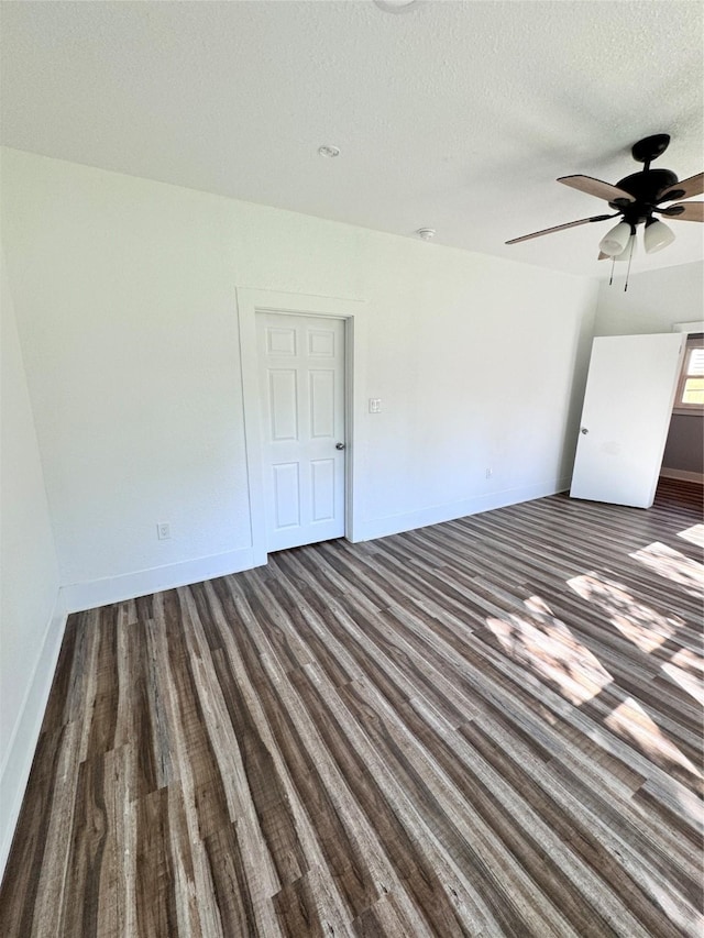 empty room featuring ceiling fan, a textured ceiling, baseboards, and wood finished floors