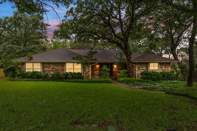 single story home with a lawn