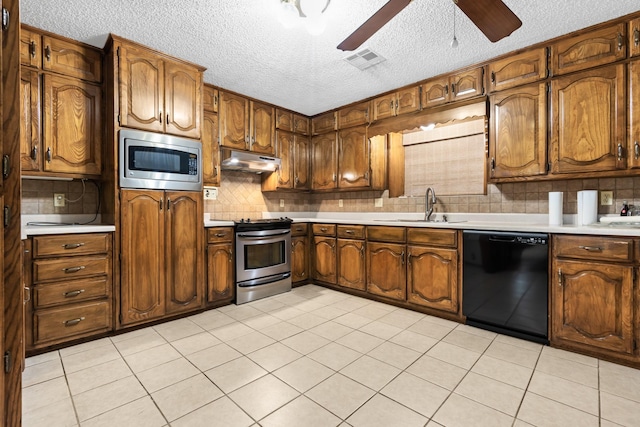 kitchen featuring decorative backsplash, sink, light tile patterned floors, and stainless steel appliances