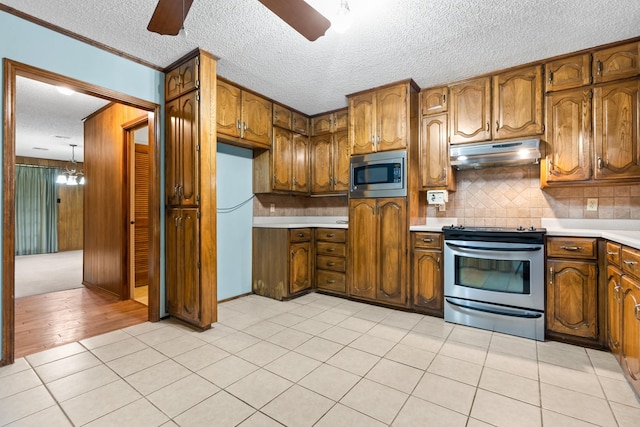 kitchen with appliances with stainless steel finishes, a textured ceiling, light tile patterned floors, and ceiling fan