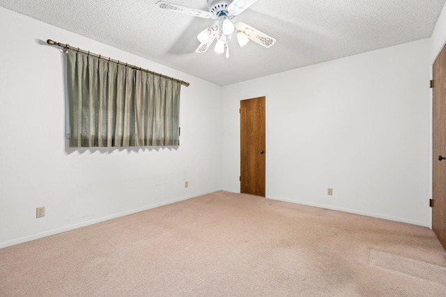 spare room with carpet flooring, ceiling fan, and a textured ceiling