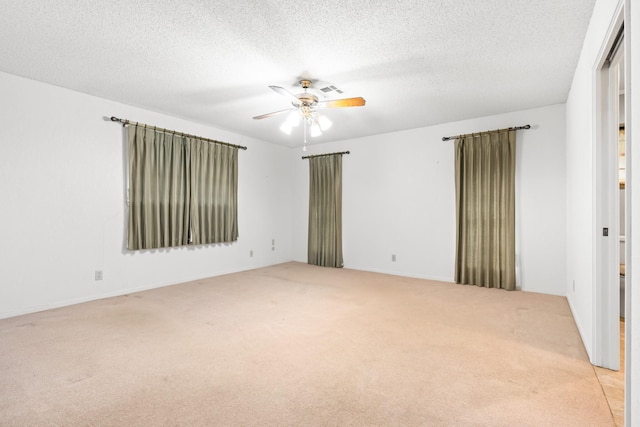 spare room with light carpet, ceiling fan, and a textured ceiling