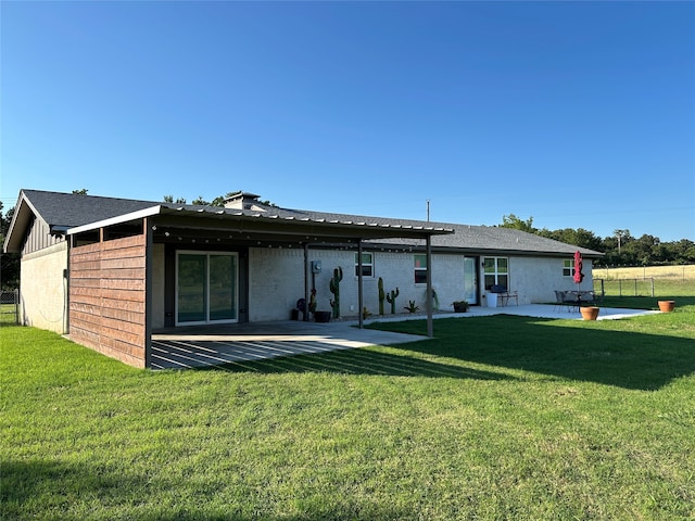 rear view of house with a yard and a patio area