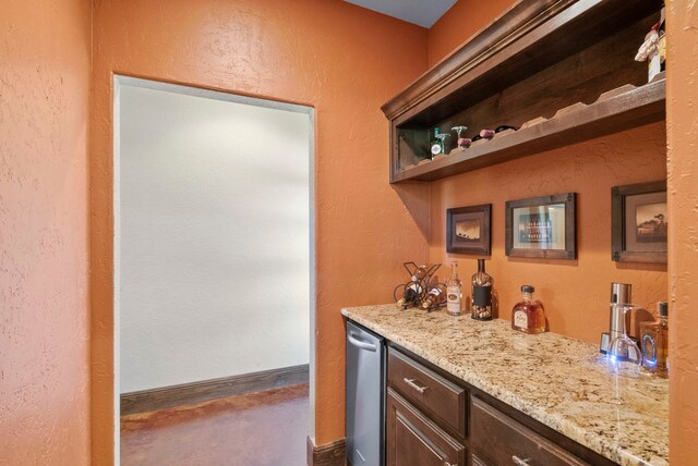 bar featuring dark brown cabinets, dishwasher, light stone counters, and carpet