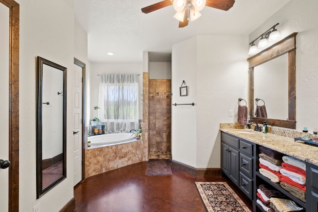 bathroom featuring ceiling fan, tiled bath, a textured ceiling, and vanity