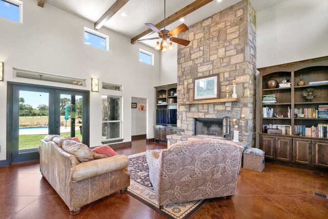 living room featuring beamed ceiling, a stone fireplace, high vaulted ceiling, ceiling fan, and dark tile floors