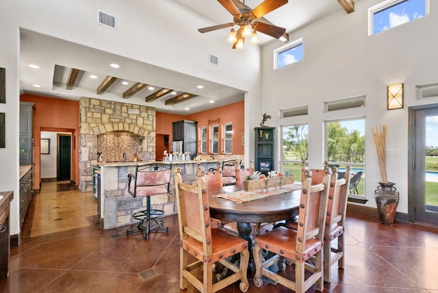 dining room featuring a high ceiling, beamed ceiling, ceiling fan, and dark tile floors