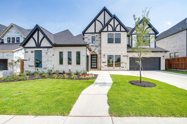 tudor home featuring a garage and a front yard