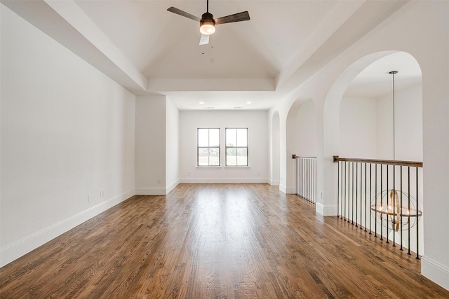 empty room with baseboards, vaulted ceiling, recessed lighting, wood finished floors, and a ceiling fan