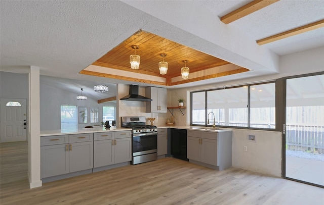 kitchen with dishwasher, wall chimney range hood, sink, hanging light fixtures, and stainless steel range with gas stovetop