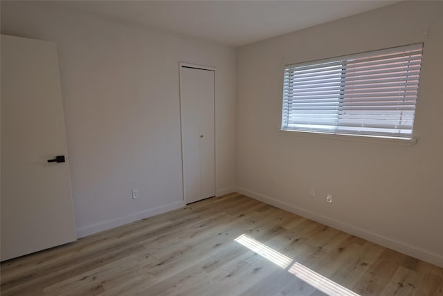 unfurnished bedroom featuring a closet and light hardwood / wood-style floors