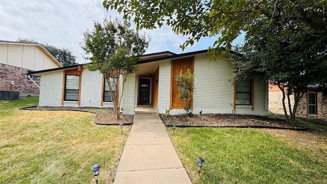 view of front facade with central air condition unit and a front yard