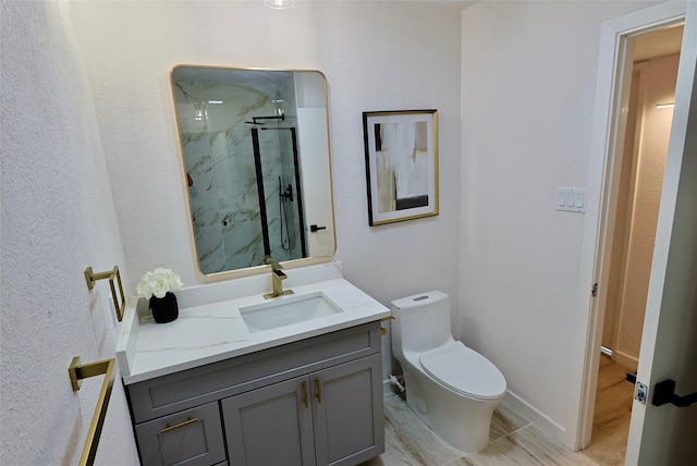 bathroom with a shower with door, vanity, and toilet