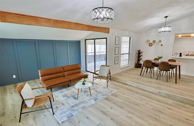 living room featuring vaulted ceiling with beams, light hardwood / wood-style floors, and an inviting chandelier