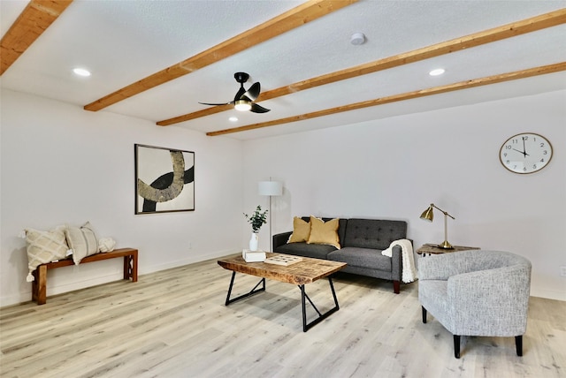 living room with beam ceiling, ceiling fan, and light hardwood / wood-style flooring