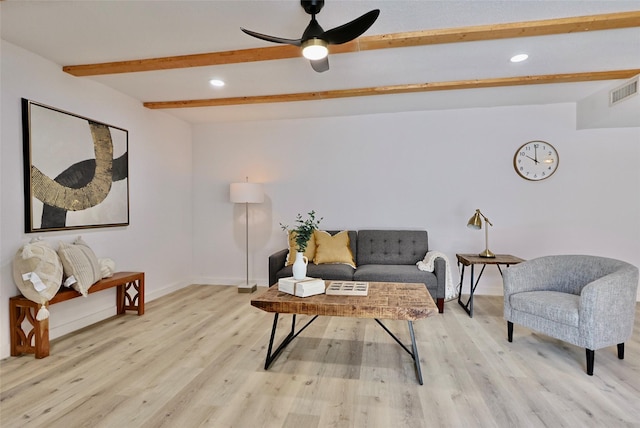 living room with ceiling fan, beam ceiling, and light wood-type flooring