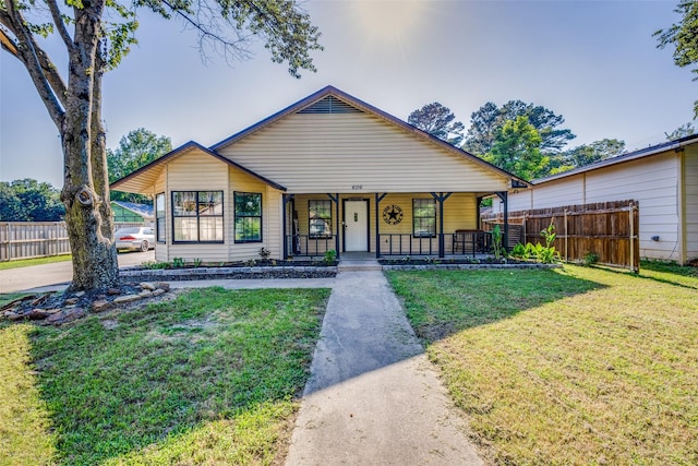 bungalow-style house featuring covered porch and a front yard