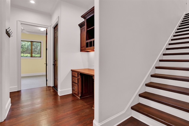 stairs featuring crown molding, dark wood-type flooring, and ceiling fan