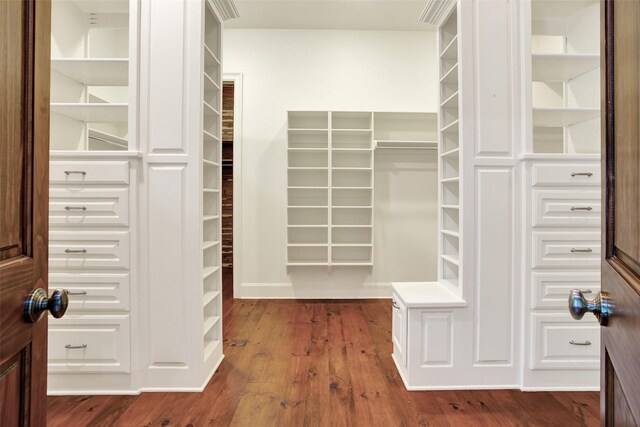 walk in closet with dark hardwood / wood-style flooring