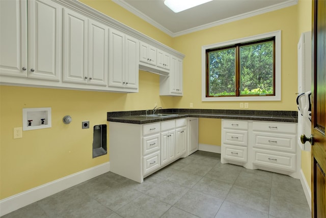 washroom with cabinet space, ornamental molding, hookup for a washing machine, electric dryer hookup, and a sink