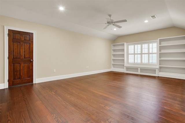 interior space featuring ceiling fan, vaulted ceiling, built in shelves, and dark wood-type flooring