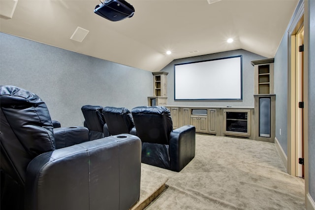 carpeted cinema with vaulted ceiling and built in shelves