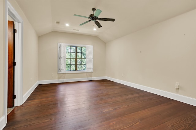 spare room featuring dark wood finished floors, visible vents, vaulted ceiling, and ceiling fan