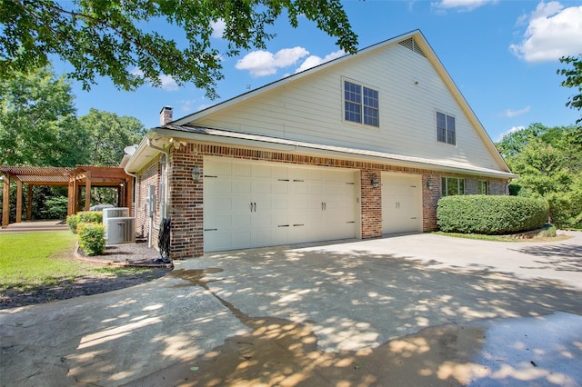 view of home's exterior featuring concrete driveway, brick siding, a chimney, and a pergola