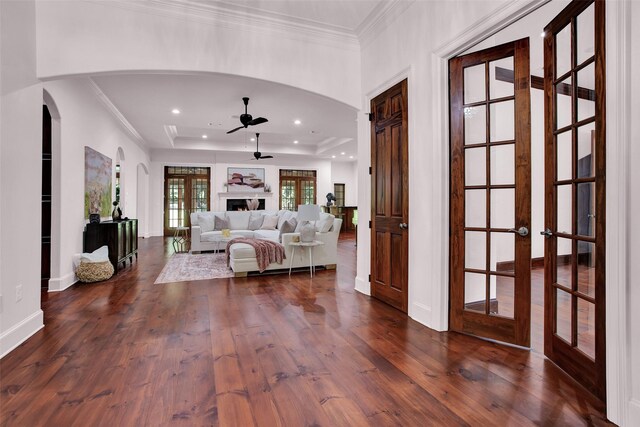 foyer with french doors, ornamental molding, dark hardwood / wood-style floors, ceiling fan, and a raised ceiling