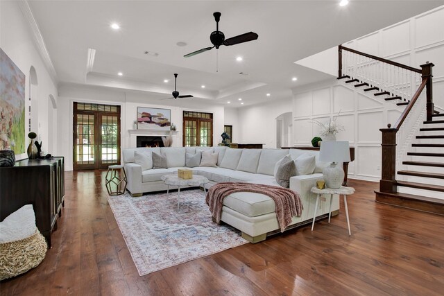 living room featuring a tray ceiling, dark hardwood / wood-style floors, and ceiling fan