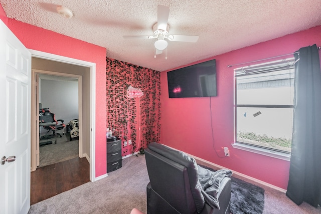 carpeted office featuring ceiling fan and a textured ceiling