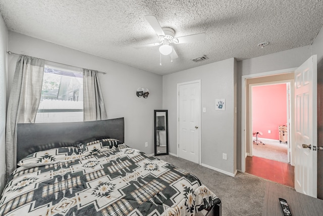 carpeted bedroom with ceiling fan and a textured ceiling